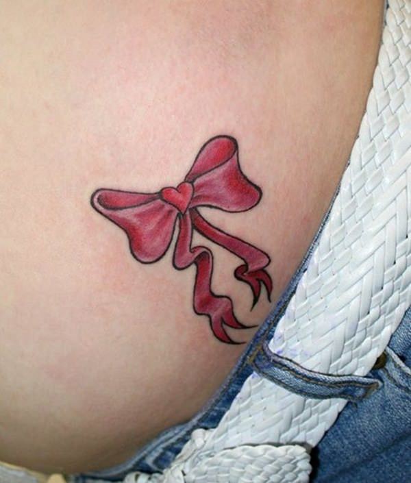 Micro-realistic ribbon tattoo located on the ankle.