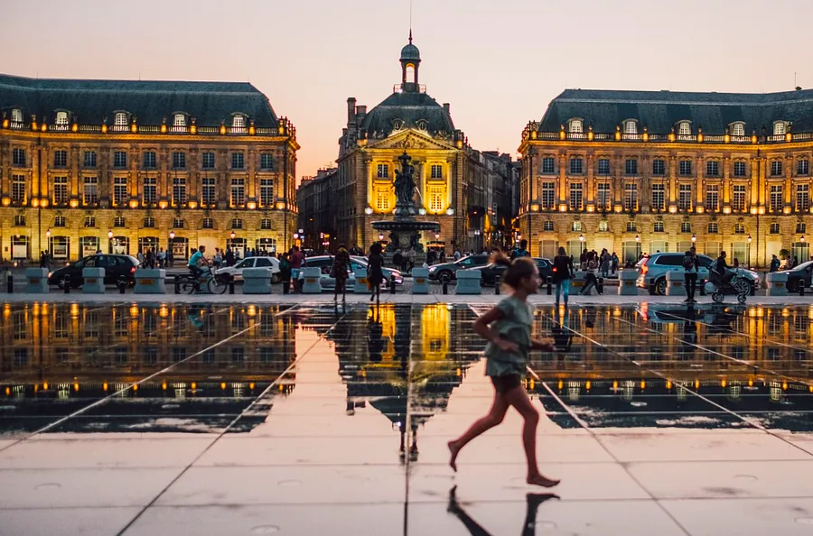 
Elegant historic buildings mirrored on a gleaming plaza in Bordeaux