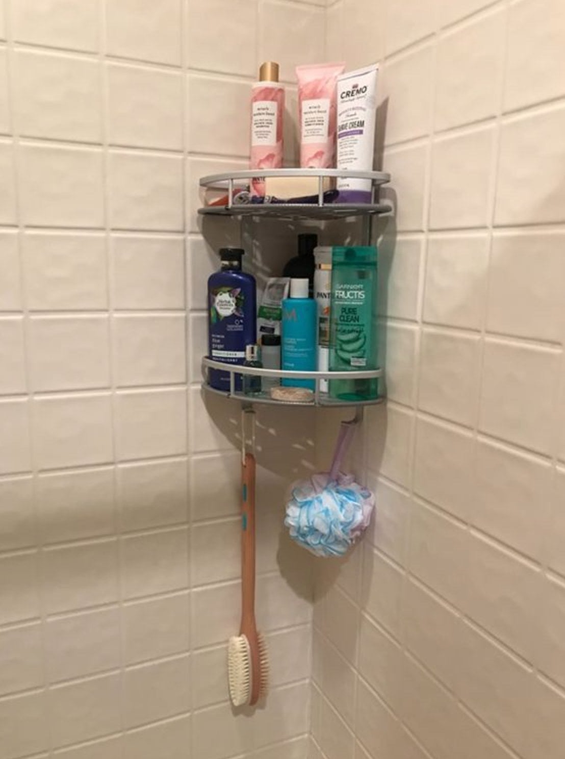 A shower caddy hanging inside a shower space.