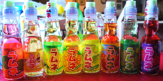 Ramune, a brand synonymous with the quirky side of Japanese sodas, offers some truly unexpected flavors like wasabi, kimchi, curry, and teriyaki, in addition to more familiar tastes such as bubble gum, white champagne, lychee, blueberry, and banana.
.
The term “ramune” is a Japanese version of the word “lemonade,” but the real star of the show is the unique Codd Stopper bottle. This cap, made of glass marble and plastic ring, provides an entertaining alternative to the usual bottle cap, as seen in a hilarious ad from Asian Food Grocer.